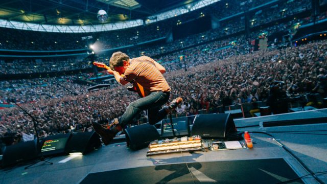 Graham Coxon of Blur caught mid-jump during the band's 2023 Wembley Stadium show